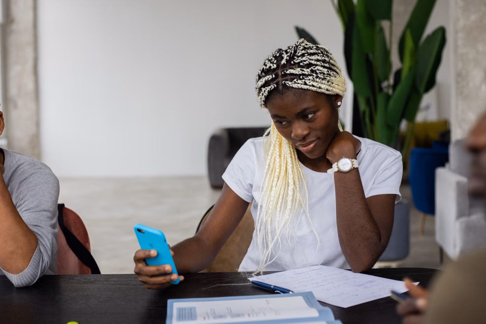 Young adult student using a smartphone during group study